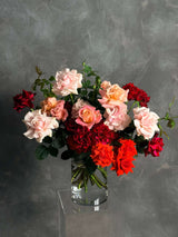 Bouquet of red, pink, and white roses in a clear vase on a gray background - valentines day roses - roses delivered Byron Bay